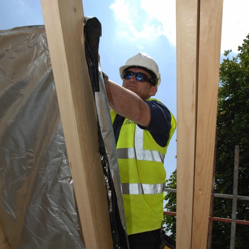 workman insulating a timber frame